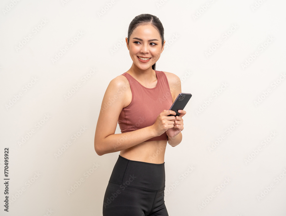 Young beautiful asian woman with sportswear using smartphone on isolated white background. Attractive Portrait latin sporty woman standing pose holding cell phone exercise workout in studio. Young beautiful asian woman with sportswear using smartphone on isolated white background. Attractive Portrait latin sporty woman standing pose holding cell phone exercise workout in studio.