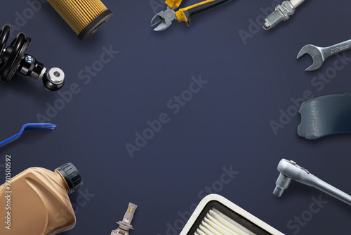 Car parts and tools neatly arranged on a clean surface with copy space in the middle. Concept of car repair and service
