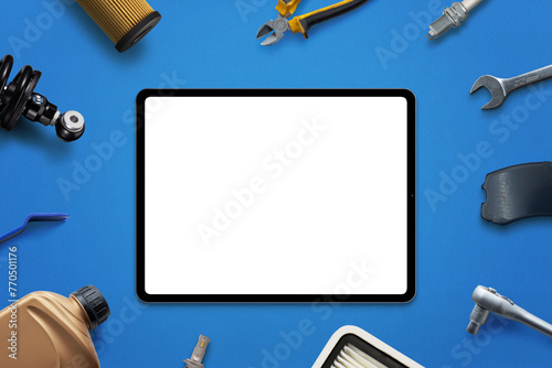Tablet mockup with isolated screen for app or web page promotion surrounded by car parts and tools. Concept of car service or part sales