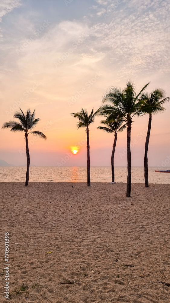 Palm trees sway gently in the breeze as a boat peacefully glides in the distance on the tranquil beach