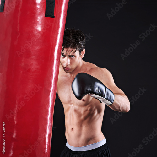 Man, punching bag and challenge with fitness, training and fighter with gloves and wellness with cardio. Boxer, practice and athlete with exercise, gym or workout with endurance on a black background