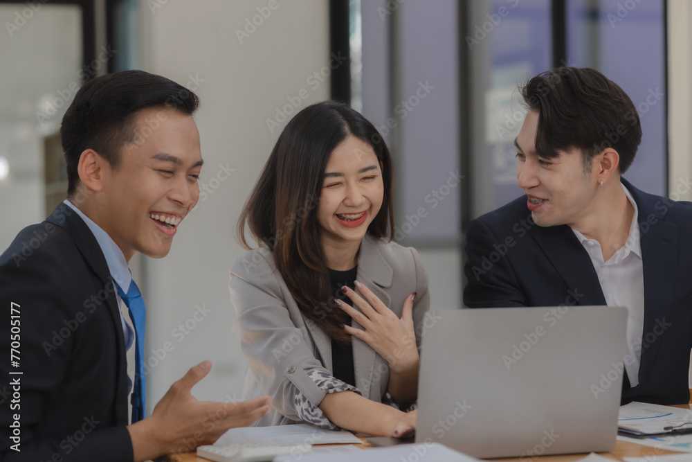 A group of employees happily work together in the office while discussing work that was completed on time as ordered by their boss, A group of entrepreneurs had fun working together.