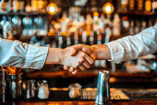 A mentor and apprentice shaking hands in a bar setting, surrounded by bartending tools, with copy space to share wisdom on mentorship and learning