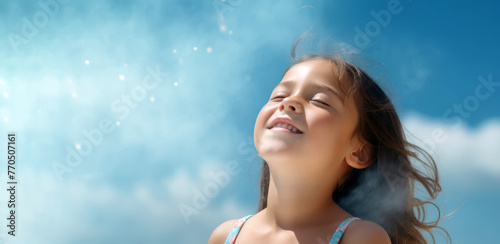 A little girl with her eyes closed smiles at the sun	
 photo