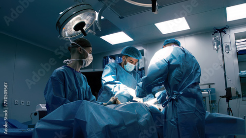 Close-up of surgeons in protective clothing in a modern operating room. Healthcare, surgery and cosmetic surgery concept.