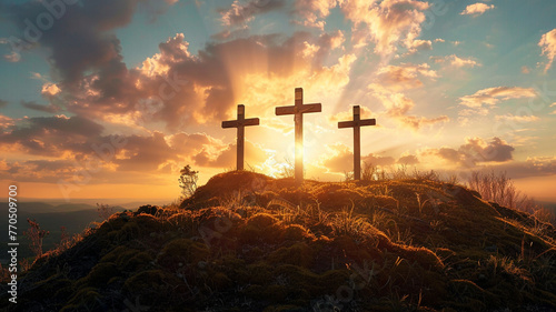 Three crosses stand a hill at sunset photo