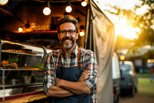 An entrepreneurial man stands arms crossed in front of his food truck, symbolizing small business pride photo