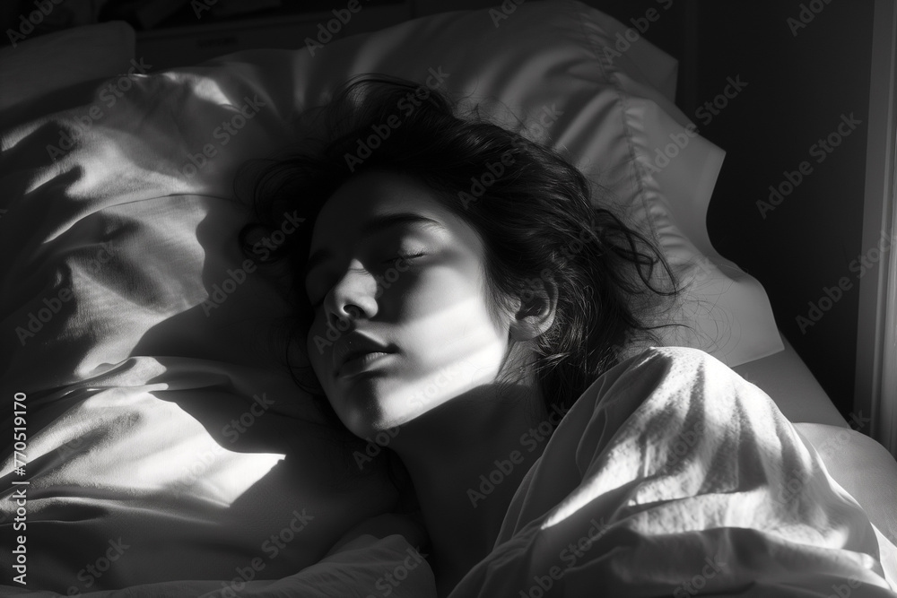Black and white portrait of young woman sleeping in bed at night.