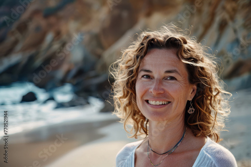 Portrait of woman with curly hair, Caucasian, her 50th, casual summer clothes, enjoys beach day, natural light enhancing joyful expression, perfect for relaxed lifestyle