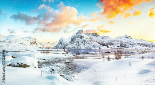Picturesque frozen Flakstadpollen and Boosen fjords with cracks on ice during sunrise with Hustinden mountain on background on Flakstadoya island photo