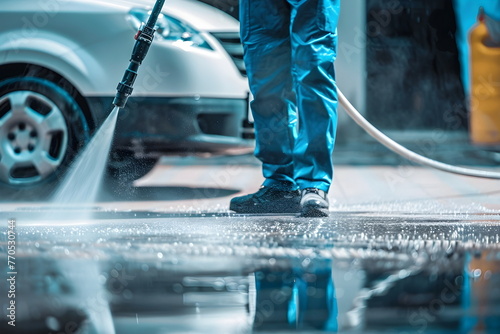 Closeup of a man holding a high pressure hose with car in the background photo