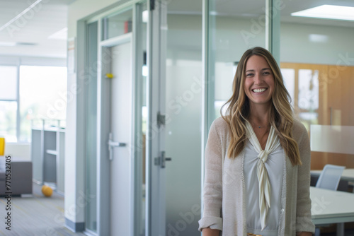 Radiant woman with a bright smile stands in a modern office corridor. Free Download Radiant woman with a bright smile stands in a modern office corridor. - GFXLoad