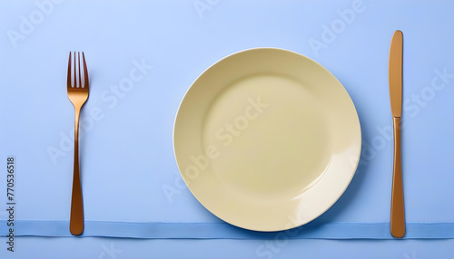 A yellow plate with a gold fork and knife on a purple background