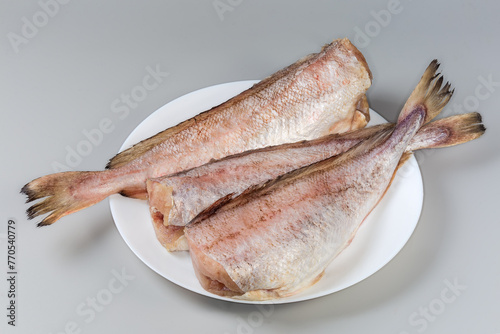 Cooled carcasses of red cod on dish on gray background photo