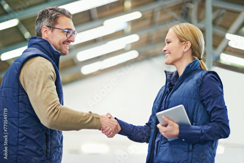 Warehouse, man and woman shaking hands, tablet and happiness for agreement or deal in storage. Business, client and supplier with smile, male person and girl together in meeting and partnership photo