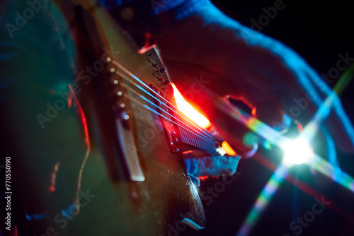 Photography Intense close-up of bass guitar playing, with colorful stage lights