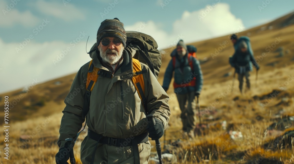 An elderly man with a gray beard, leading a group of hikers in the mountain landscape, showing experience and endurance