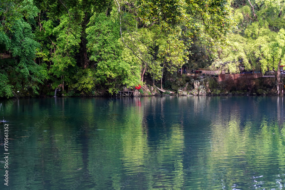 Beautiful view of the blue lake surrounded by trees around it. Beautiful view of the blue lake surrounded by trees around it.