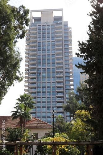 Tel Aviv Israel 03/28/2024. Buildings and structures of Tel Aviv through the foliage of tall trees. photo