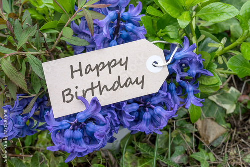 Bouquet of blue hyacinths and card with English text: Happy Birthday