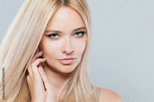 Perfect woman face close-up. Blonde model with fresh clear skin and healthy silky hair on white background