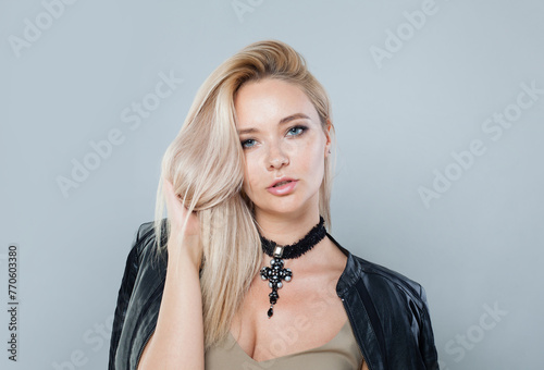 Studio portrait of young woman with make-up and long blonde hair against white wall background