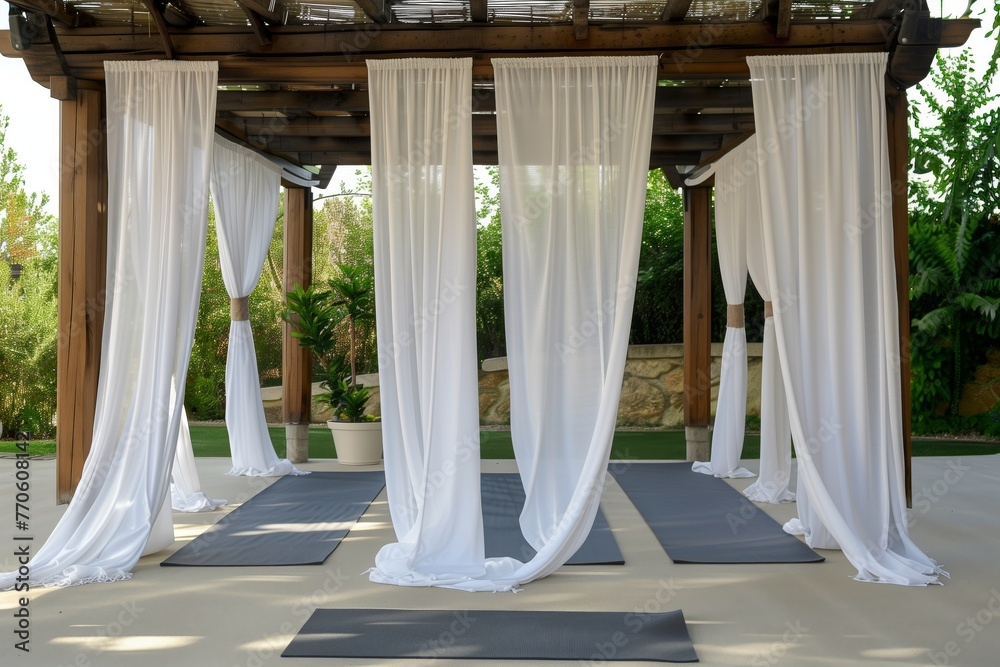 yoga session on a mat under a pergola with white curtains