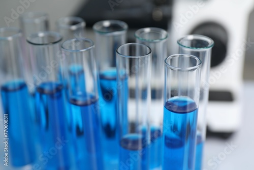Laboratory analysis. Test tubes with blue liquid on table, closeup