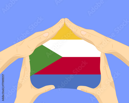 Hand home with Comoros flag, residential or investment idea, housing and home concept