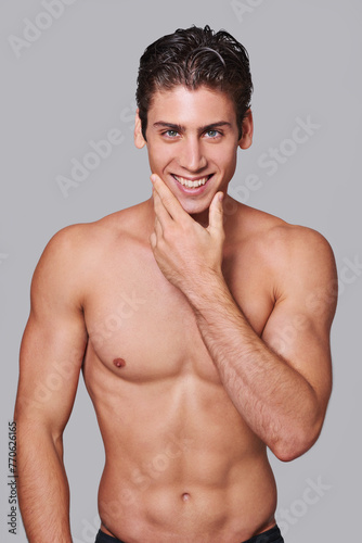 Man, skincare and smile in studio portrait with hand on face for wellness by gray background. Person, model and facial dermatology for self care, health or transformation for happy, pride or results