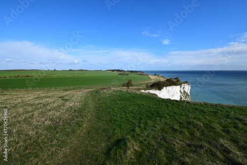  Windswept landscape of lush green meadows ending in the white cliffs of Dover, Kent, UK