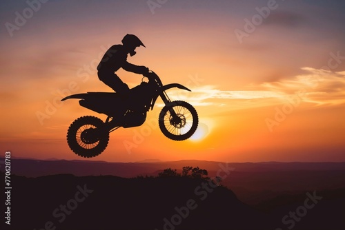jumping motorcyclist silhouetted against the sunset