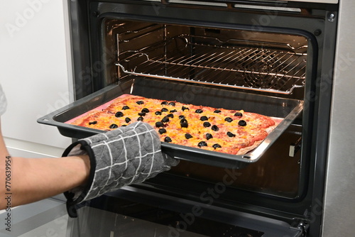 Making pizza, taking out pizza from an oven
