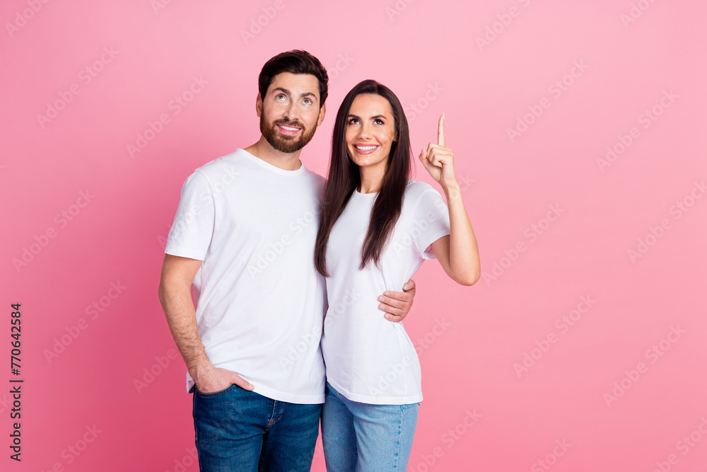 Photo portrait of nice young couple hug point look up empty space dressed stylish white outfit isolated on pink color background Photo portrait of nice young couple hug point look up empty space dressed stylish white outfit isolated on pink color background