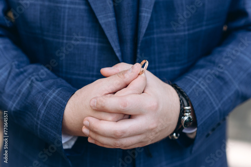 groom holds hands on wrist