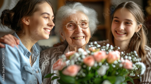 Joyful grandmother with grandchildren sharing a loving moment over birthday flowers.