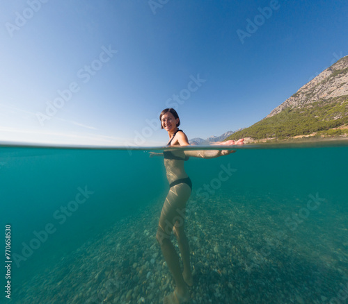 Woman on tropical vacation paradise on sea. Summer sea joy in Turkish seacoast, beaches along Lycian Way, Turkish Riviera. Asian female underwater and turquoise ocean around.