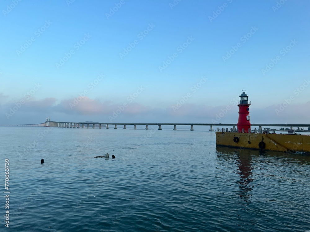Idyllic coastal scene featuring a bright yellow lighthouse standing on a beach