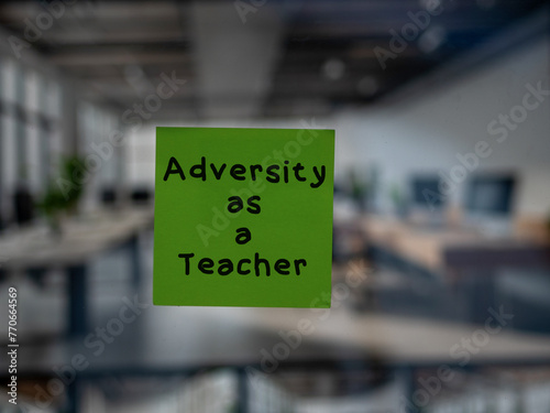 Post note on glass with 'Adversity as a Teacher'.