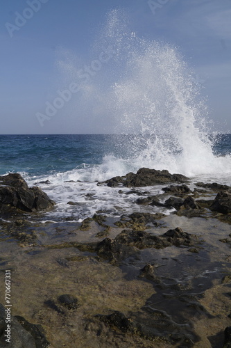 onda che si schianta sulle rocce della costa, scogli, con schizzi, spruzzi d'acqua che si proiettano per vari metri,dati dalla forza dell'impatto, onde dell'oceano atlantico,scattate a fuerteventura