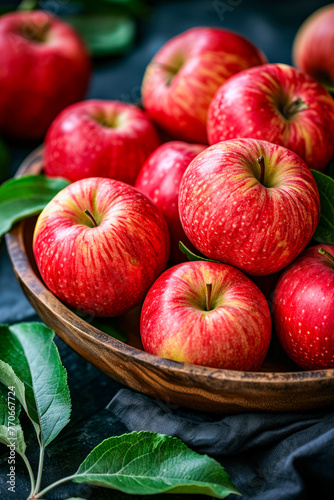 Wooden bowl is filled with red apples.