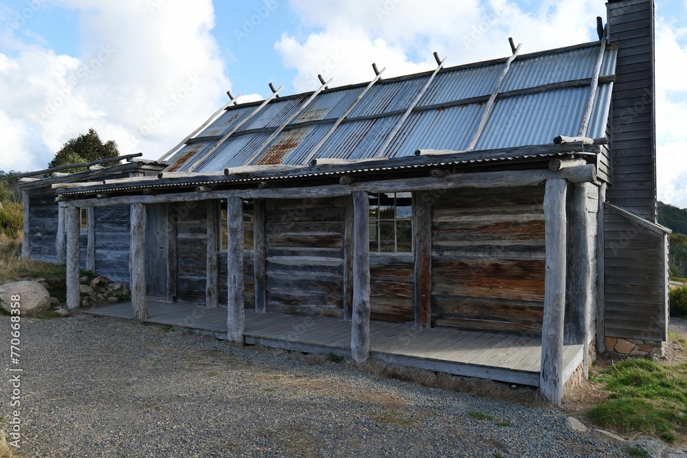 Old, dilapidated log cabin with a weathered shingled roof