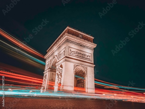 Long exposure nighttime photo of Arc de Triomphe on Champs Elysees avenue, Paris, France
