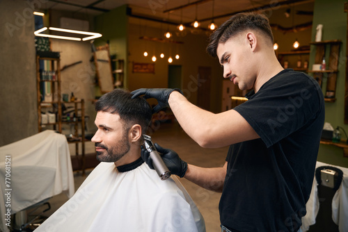Bearded man getting new hairstyle at barbershop