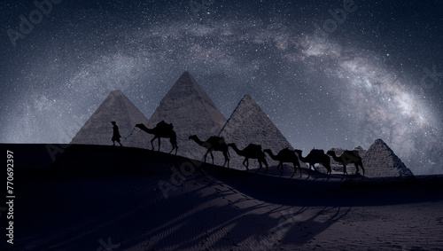 Camel caravan in front of the Great pyramid of Giza complex - The Milky Way rises over the Pyramids in Giza, Egypt