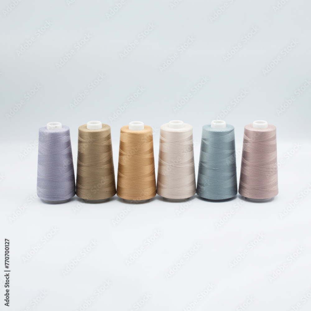 Thread spools background. Various colors sewing kit. Collection of threads. Pale pastel colors. Sew threads. Colorful hobby background. Tailor shop texture. Isolated on white. Thread spools background. Various colors sewing kit. Collection of threads. Pale pastel colors. Sew threads. Colorful hobby background. Tailor shop texture. Isolated on white.