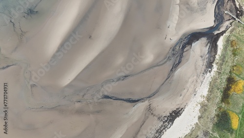 a view of the sand and water from the air with a view of the shore photo