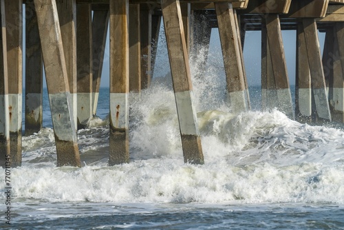 Waves crash against pier foundation in windy weather