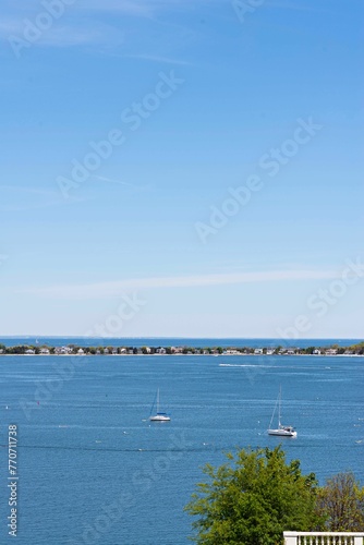 a view over the ocean with boats in the distance and trees around
