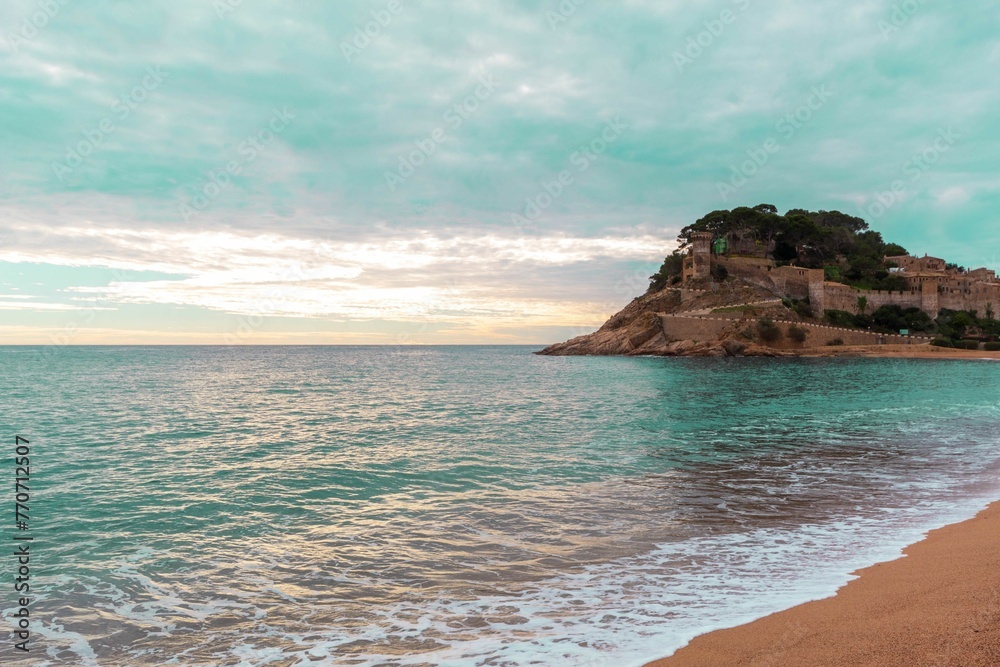 Old castle on a rocky hill on the tropical beach with white sands in Tossa De Mar - obrazy, fototapety, plakaty 